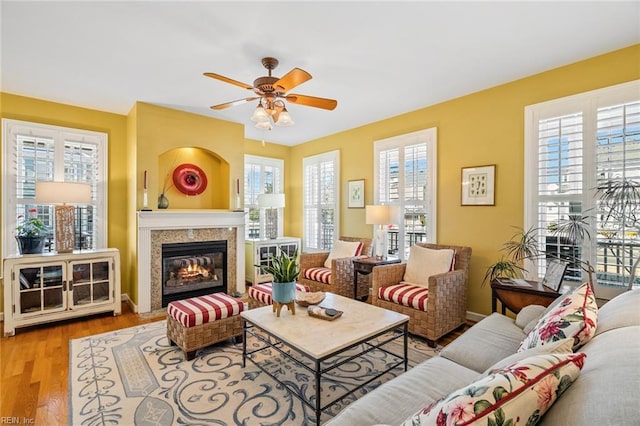 living room with light hardwood / wood-style floors, ceiling fan, and plenty of natural light