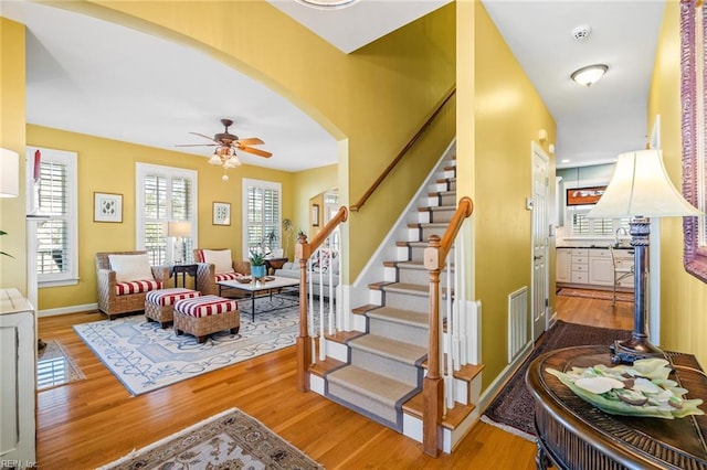 stairway with ceiling fan and hardwood / wood-style flooring