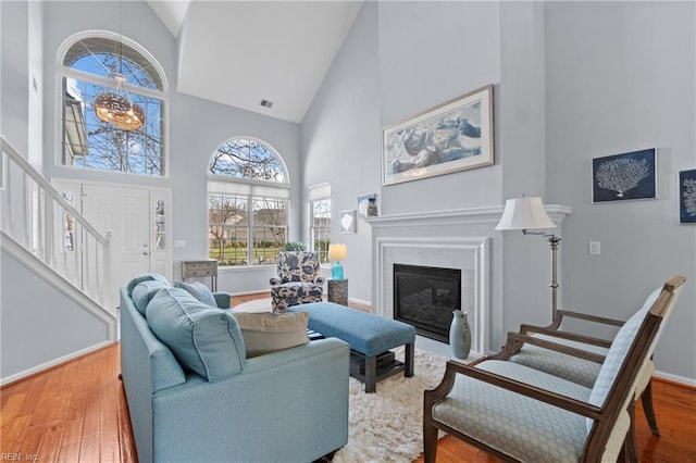 living room with hardwood / wood-style floors and high vaulted ceiling