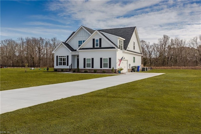 view of front of home with central AC unit, a garage, and a front lawn