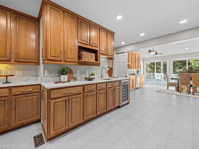 kitchen with sink, ceiling fan, beverage cooler, and stainless steel dishwasher