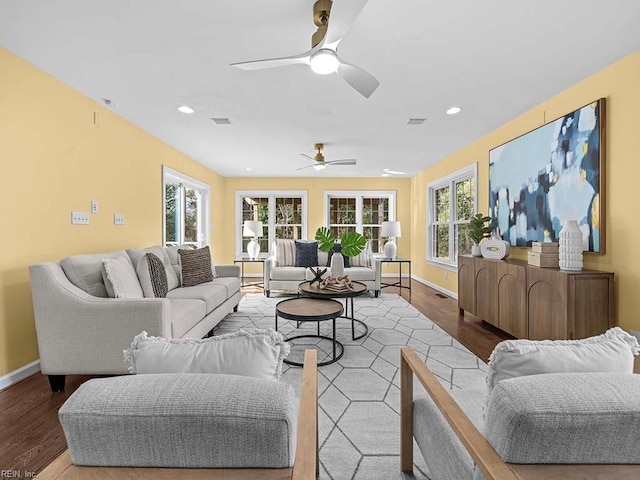 living room featuring ceiling fan, light wood-type flooring, and plenty of natural light