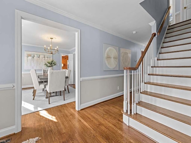 entrance foyer with wood-type flooring, a chandelier, and crown molding