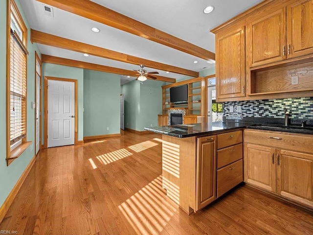 kitchen with sink, beamed ceiling, tasteful backsplash, light hardwood / wood-style flooring, and kitchen peninsula