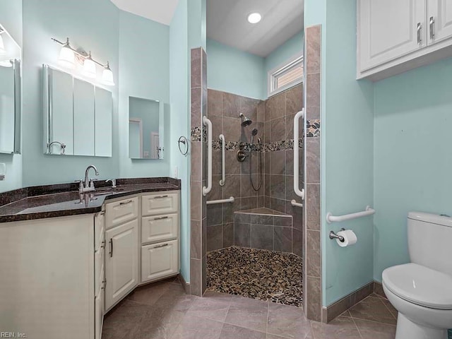 bathroom featuring tiled shower, tile patterned flooring, vanity, and toilet