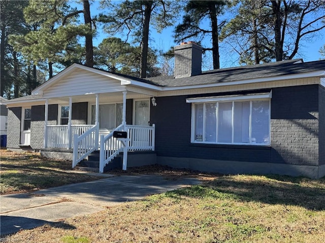 ranch-style house featuring a porch and a front lawn