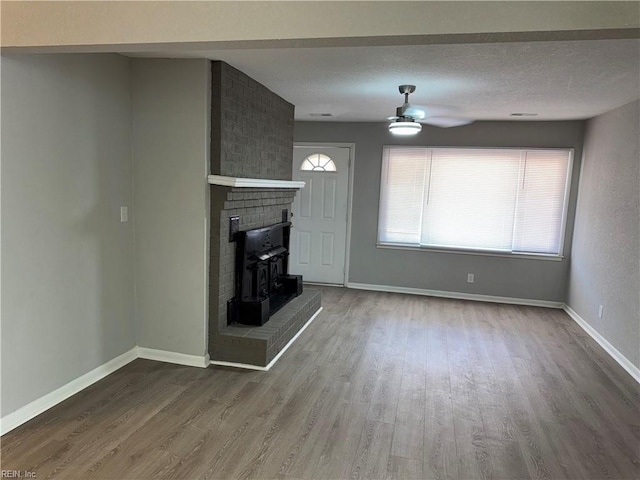 unfurnished living room featuring hardwood / wood-style floors, a textured ceiling, and ceiling fan