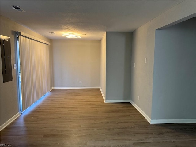 unfurnished room featuring hardwood / wood-style floors and electric panel