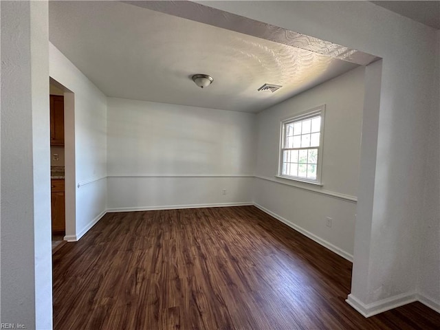 spare room with dark hardwood / wood-style flooring