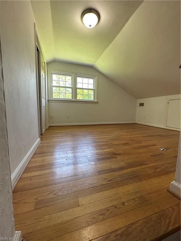 bonus room featuring wood-type flooring and vaulted ceiling