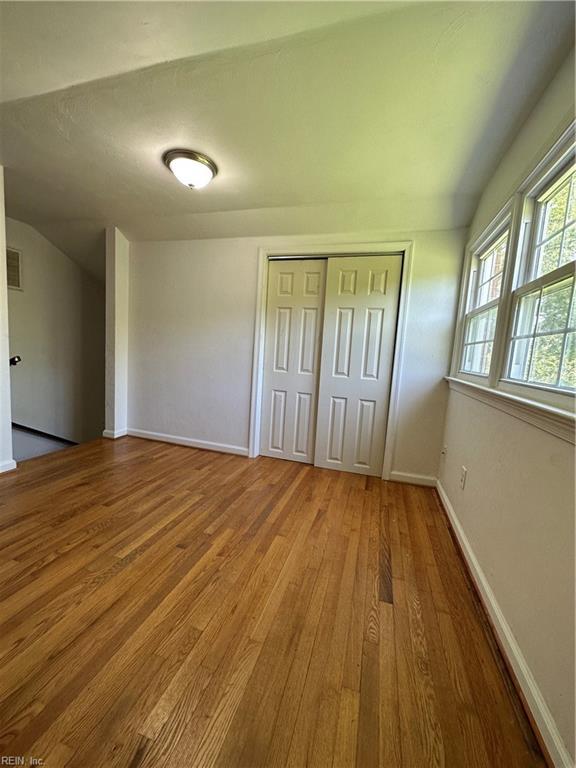 unfurnished bedroom with wood-type flooring and a closet