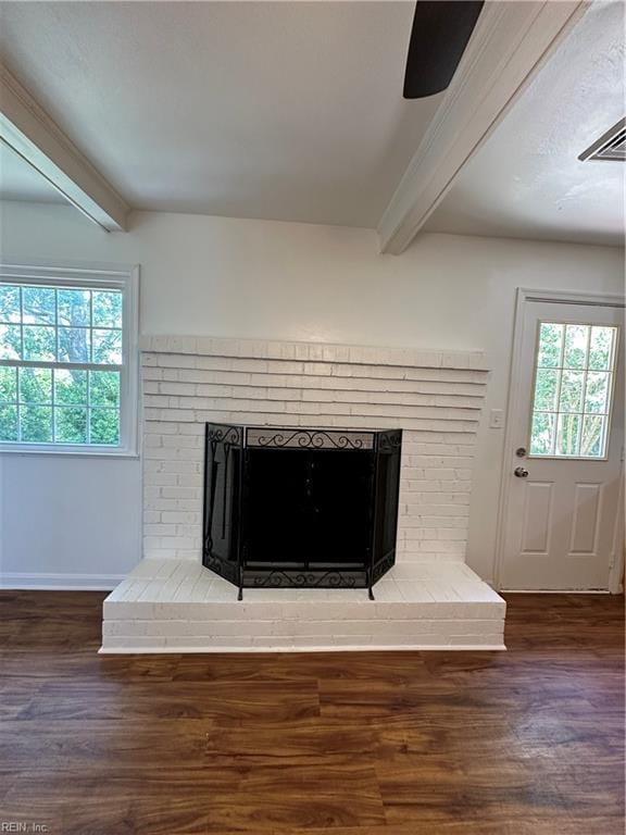 room details featuring beam ceiling, hardwood / wood-style flooring, a brick fireplace, and ceiling fan