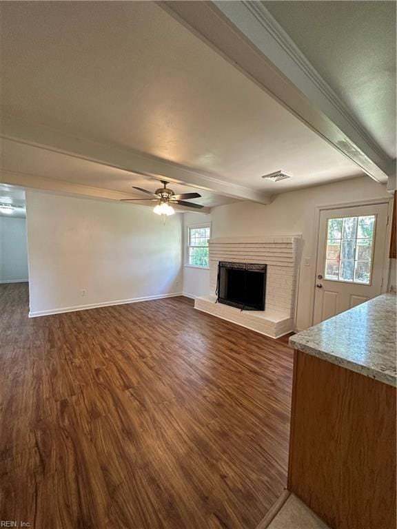 unfurnished living room with ceiling fan, dark hardwood / wood-style flooring, and beamed ceiling