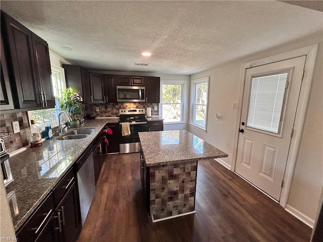 kitchen featuring backsplash, sink, a center island, and appliances with stainless steel finishes