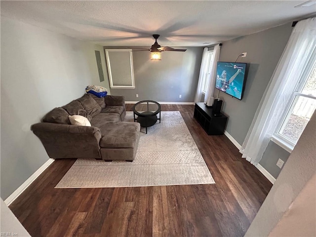 living room with ceiling fan, dark hardwood / wood-style flooring, and a textured ceiling