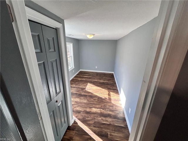 hall featuring dark hardwood / wood-style floors and a textured ceiling