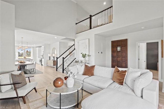 living room featuring a towering ceiling and light hardwood / wood-style flooring