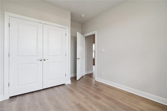 unfurnished bedroom with light hardwood / wood-style flooring and a closet