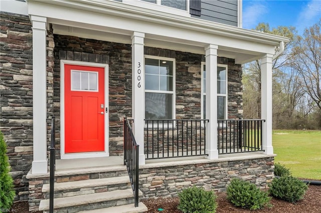 property entrance featuring a yard and a porch