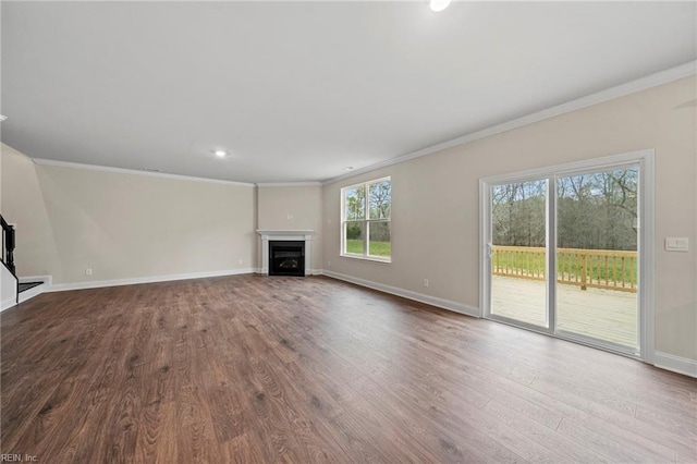 unfurnished living room with crown molding, a healthy amount of sunlight, and wood-type flooring