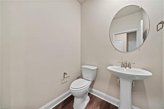 bathroom featuring hardwood / wood-style flooring and toilet