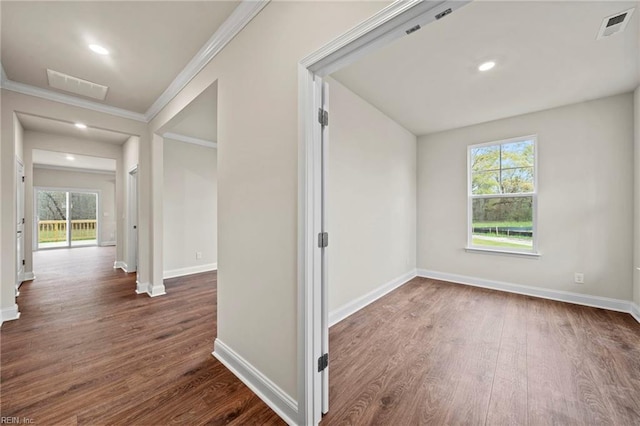 corridor with dark hardwood / wood-style flooring, crown molding, and a wealth of natural light