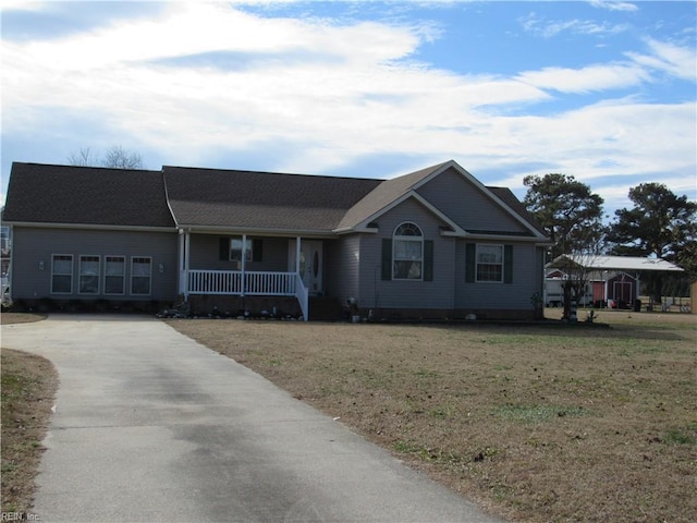 ranch-style home featuring a front lawn and covered porch