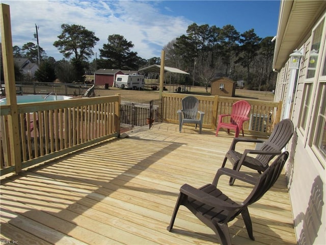 deck with a swimming pool and a storage shed