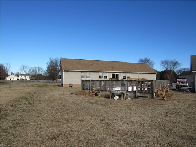 rear view of house featuring a yard and a deck