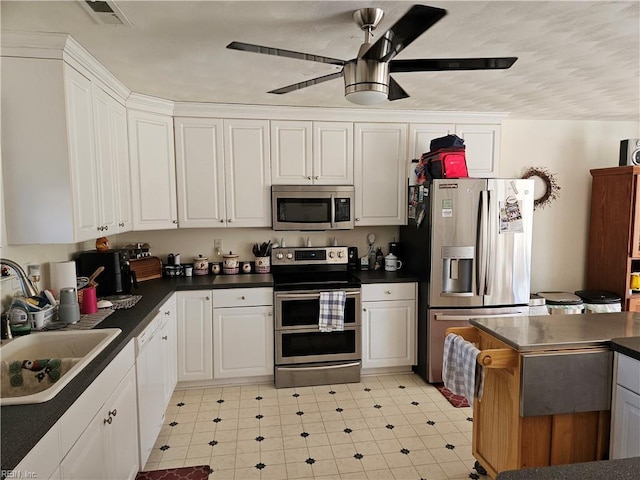 kitchen featuring white cabinets, stainless steel appliances, ceiling fan, and sink