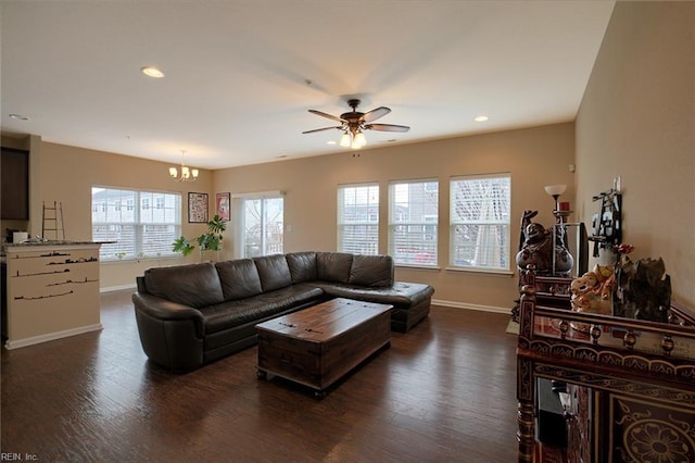 living room featuring ceiling fan with notable chandelier and dark hardwood / wood-style floors