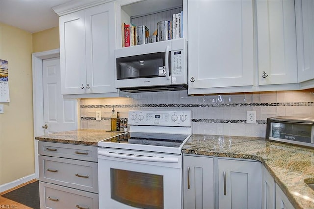 kitchen featuring white appliances, light stone counters, decorative backsplash, white cabinetry, and wood-type flooring