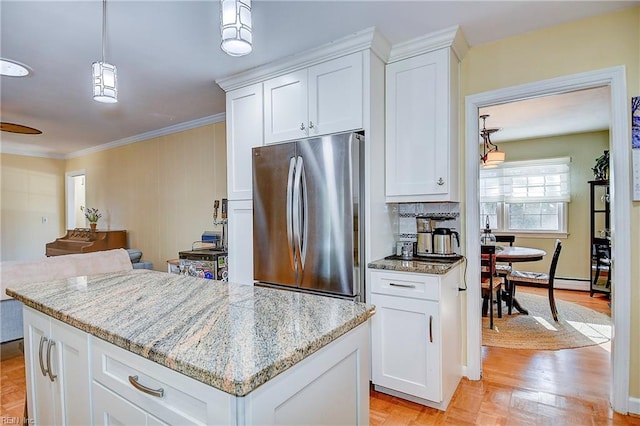 kitchen with a center island, light stone countertops, stainless steel fridge, pendant lighting, and white cabinets