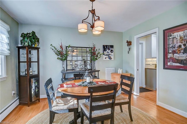 dining room with light wood-type flooring, an inviting chandelier, plenty of natural light, and a baseboard heating unit