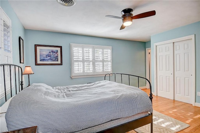 bedroom featuring ceiling fan, light wood-type flooring, and a closet