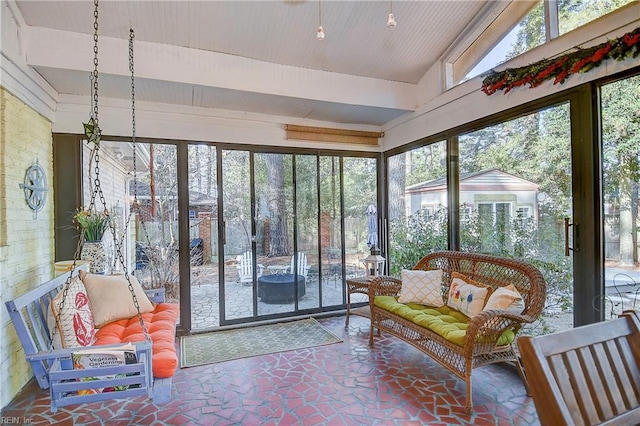 sunroom with lofted ceiling and a healthy amount of sunlight