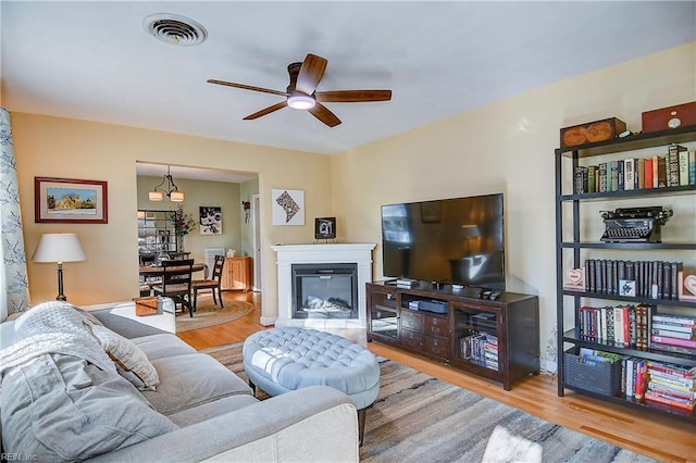 living room with ceiling fan and light hardwood / wood-style flooring