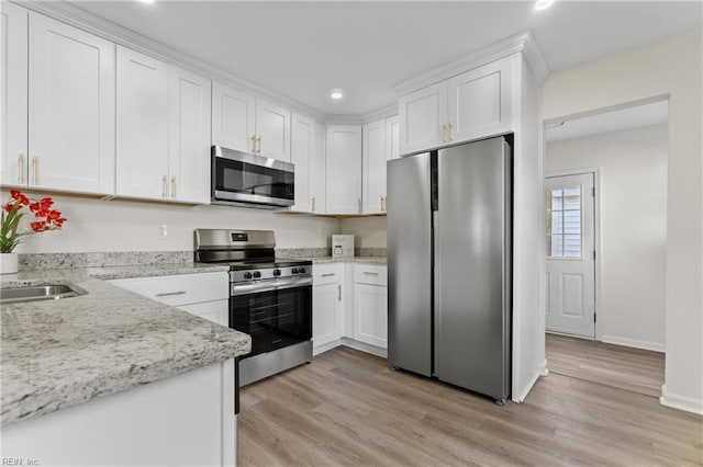 kitchen featuring white cabinets, stainless steel appliances, and light wood-type flooring