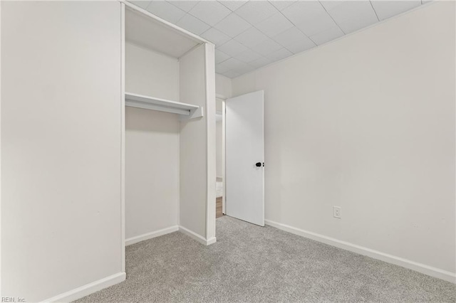 unfurnished bedroom featuring light colored carpet and a closet