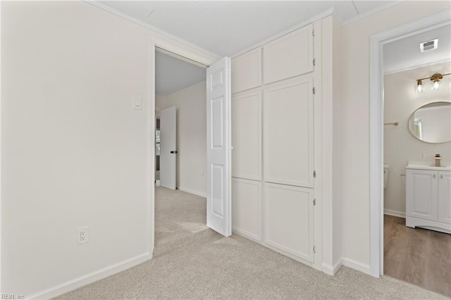 hall with light carpet and crown molding