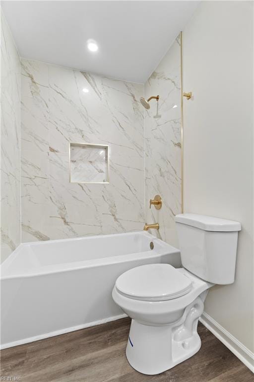 bathroom featuring toilet, tiled shower / bath combo, and hardwood / wood-style flooring