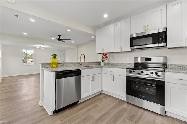 kitchen featuring stainless steel appliances, kitchen peninsula, ceiling fan, white cabinets, and sink