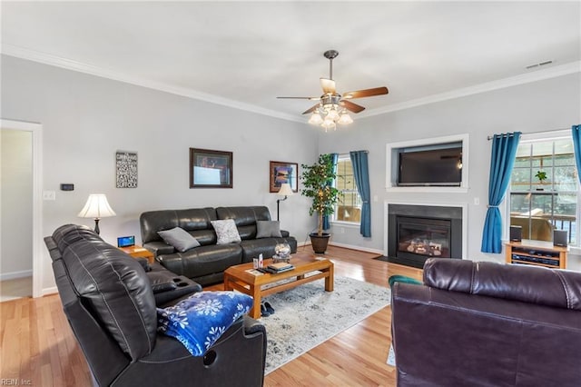 living room with light hardwood / wood-style floors, crown molding, and ceiling fan