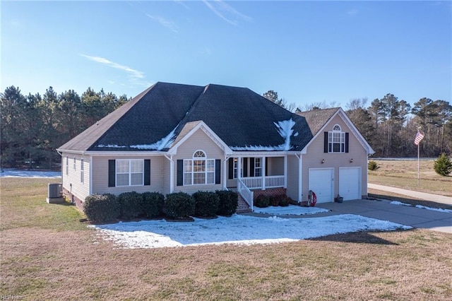 view of front of house with a front yard, covered porch, and a garage