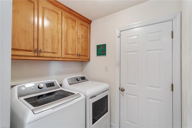 clothes washing area featuring cabinets and independent washer and dryer