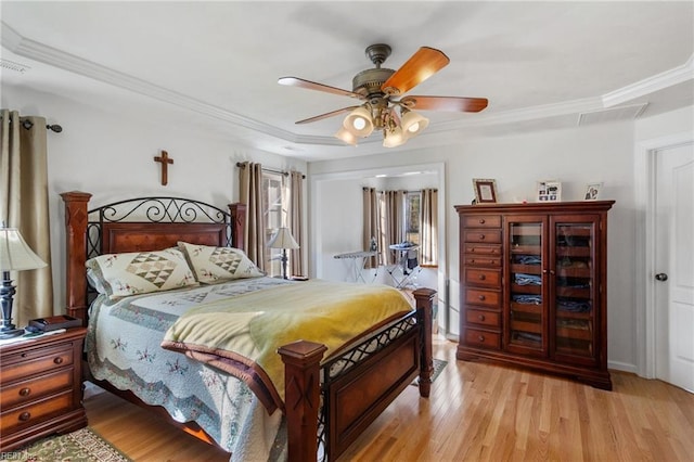 bedroom featuring ceiling fan, ornamental molding, and light wood-type flooring