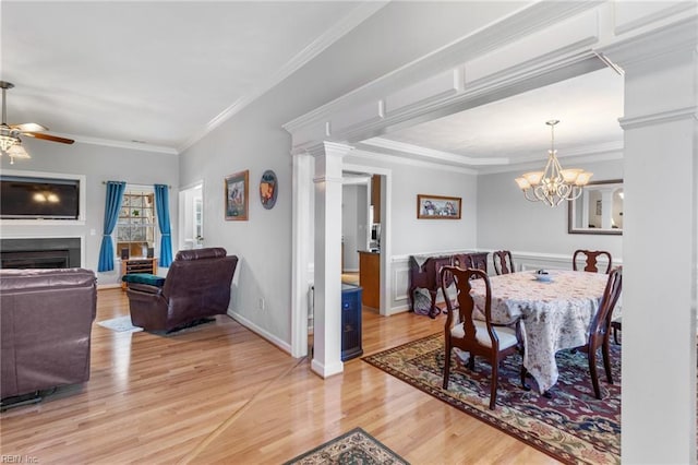 dining area with ceiling fan with notable chandelier, light hardwood / wood-style flooring, and crown molding