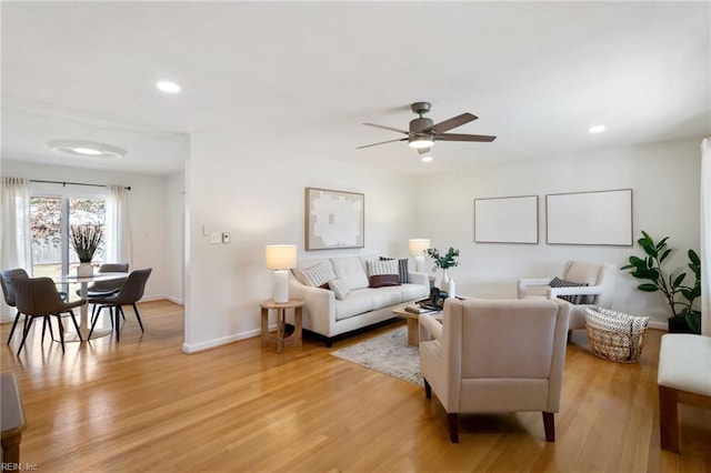 living room with light hardwood / wood-style flooring and ceiling fan