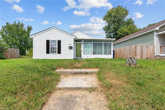 view of front of property with a sunroom and a front lawn