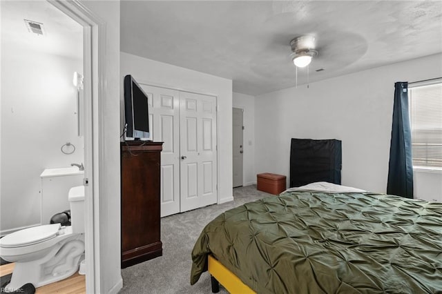 carpeted bedroom featuring ceiling fan and a closet